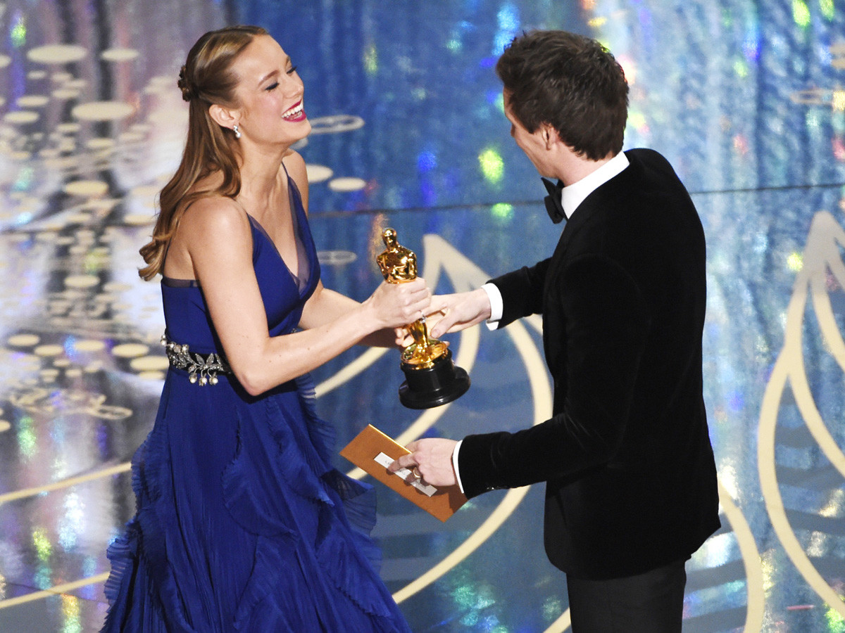 Eddie Redmayne, right, presents Brie Larson with the award for best actress